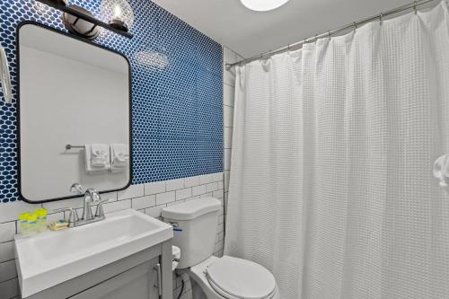 une salle de bain avec toilettes, lavabo et miroir dans l'établissement Cabana Beach #5 Condo Steps from the Beach, à Myrtle Beach