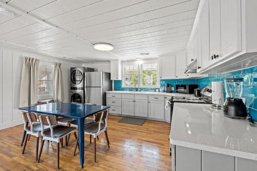 une cuisine avec des placards blancs et une table et des chaises bleues dans l'établissement Cabana Beach #6 Condo Steps from the Beach, à Myrtle Beach