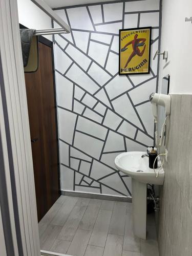 a bathroom with a white sink and a wall at ApartHotel Crescenzago House in Milan