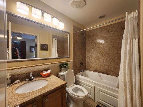 a bathroom with a sink and a toilet and a mirror at Orlando 1st Floor - 5 min Disney in Orlando