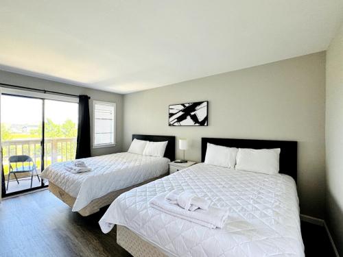 a bedroom with two beds and a balcony at Bay tree lovely one bedroom condo in Little River