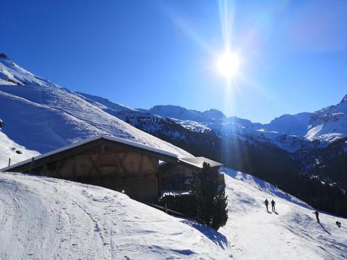 two people skiing down a snow covered slope next to a building at KARWENDELBLICK - ein idyllischer Wohlfühlort in Wattenberg