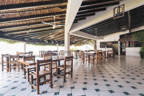 a restaurant with wooden tables and chairs in a building at Departamento en Teques in Tequesquitengo