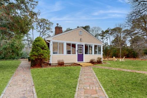 a small white house with a purple door at Herring Brook in Eastham