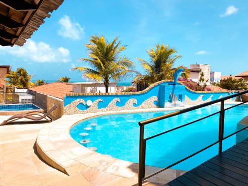 a swimming pool in a resort with palm trees at Planet Dunas Residence in Aquiraz