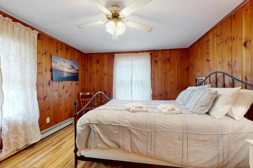 a bedroom with a bed with a wooden wall at Herring Brook in Eastham