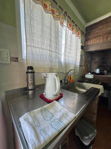 una cocina con fregadero y una batidora en una encimera en El quincho, en San Pedro