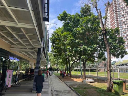 a woman walking down a sidewalk next to a building at Ortigas Business District Residences in Manila