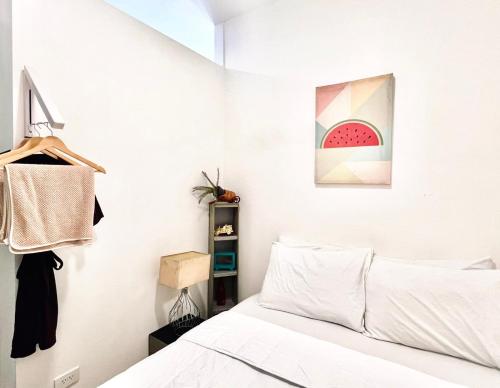 a bedroom with a bed and a painting of a watermelon at Ortigas Business District Residences in Manila