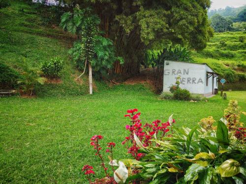 a sign in the grass with flowers in a yard at Gran Tierra - Sabaneta in Medellín