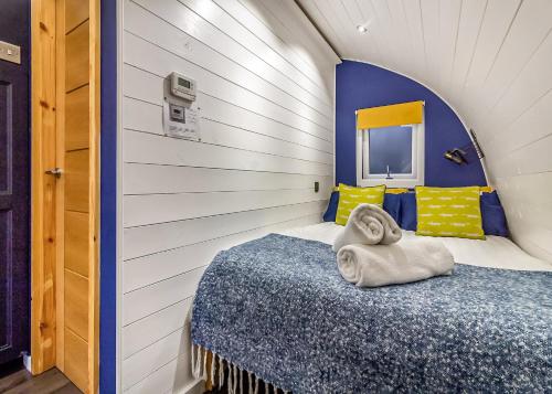 a small bedroom with a bed with a towel on it at Peacock Lake Glamping in East Bridgford