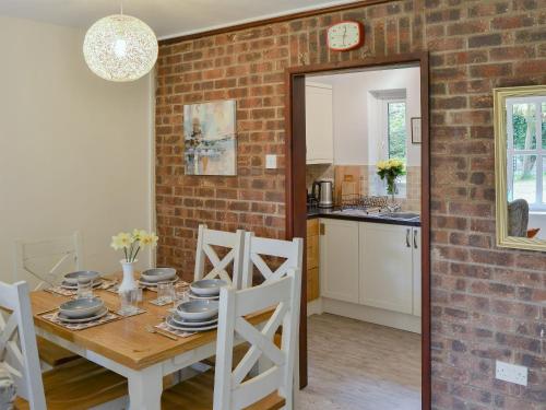a kitchen and dining room with a brick wall at Villa 9 in Cromer