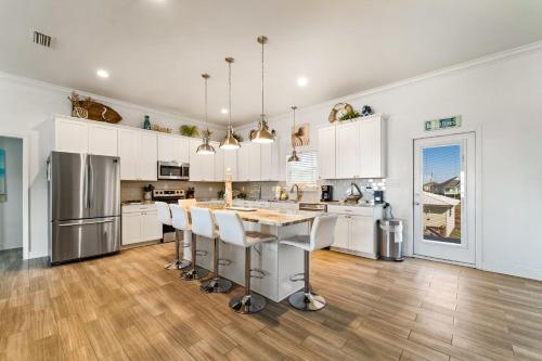 eine Küche mit weißen Schränken und einem Holzboden in der Unterkunft Newer Large Beachside 6 Bedroom House 3000 Sq Ft Sleeps 22 in Dauphin Island