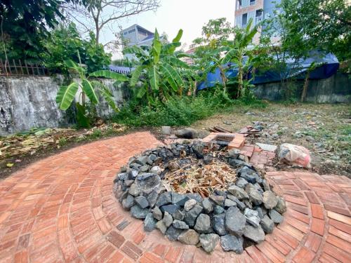 a fire pit in a brickicked yard with a fire pitificialificialificialificial at Derm Svay Guesthouse - yoga & cafe in Kampot