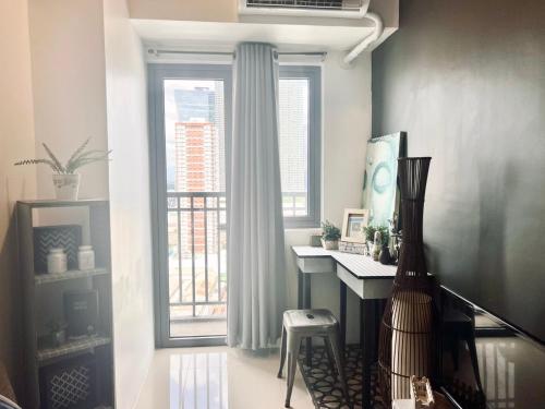 a room with a desk and a large window at Ortigas Business District Prime Accommodations in Manila