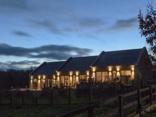 a house lit up at night with lights at Three The Old Stables in Knitsley