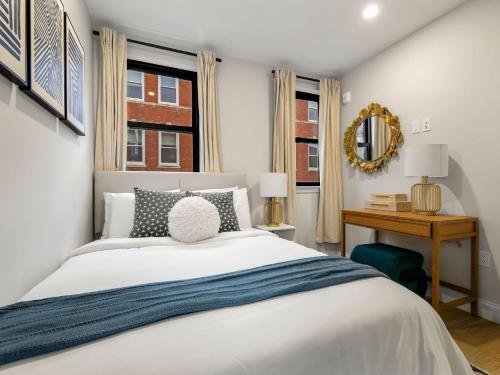 a bedroom with a bed and a table with a mirror at North End Apt close to TD Garden Walk to Downtown in Boston