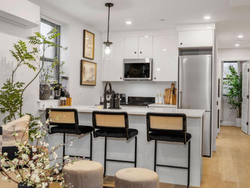 a kitchen with a counter with stools and a refrigerator at North End Apt close to TD Garden Walk to Downtown in Boston
