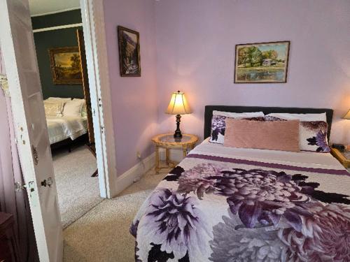 a bedroom with a bed and a table with a lamp at The Kings Throne Inn and Guest House in Toledo