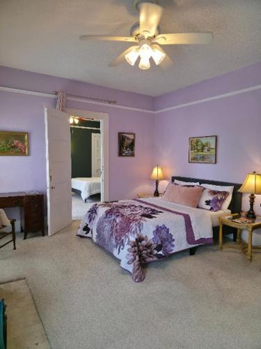 a bedroom with a bed and a ceiling fan at The Kings Throne Inn and Guest House in Toledo
