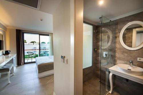 a bathroom with a sink and a glass shower at As Hotel Cesme in Çeşme