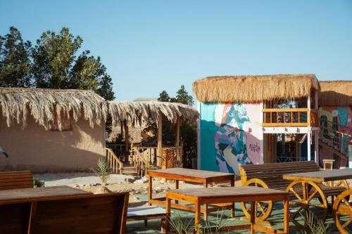 a group of tables and chairs in front of a building at Green Beach Camp & Hotel in Nuweiba