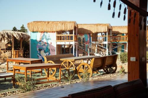 a building with a horse drawn carriage and tables at Green Beach Camp & Hotel in Nuweiba