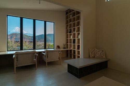 a room with a large window and a table and bench at 富士山望むプライベートヴィラ 900平方メートルの敷地を貸切利用 憩 ikoi Fuji サウナ 4Kシアター in Fujikawaguchiko