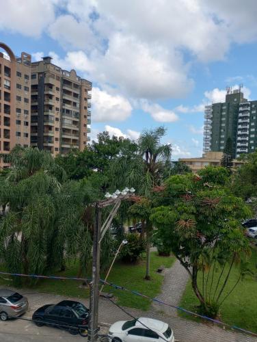 a parking lot with cars parked in a park at Vila Caiçara 80 metros da praia in Praia Grande