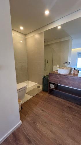 a bathroom with a toilet and a sink and a mirror at Vila Mar Guest House in Vila do Conde