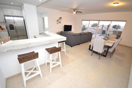 a kitchen and living room with a couch and a table at Ocean View Condo with Pools and Easy Beach Access in Las Conchas