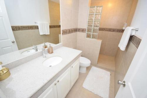 a white bathroom with a sink and a toilet at Ocean View Condo with Pools and Easy Beach Access in Las Conchas