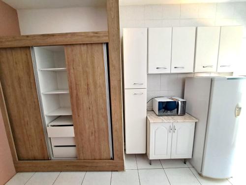 a kitchen with white cabinets and a refrigerator at 10 Studios in Sao Paulo