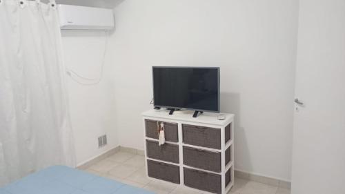 a tv sitting on top of a dresser in a room at Departamento Temporario en Tres Arroyos in Tres Arroyos