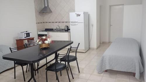 a kitchen with a table and chairs and a refrigerator at Departamento Temporario en Tres Arroyos in Tres Arroyos