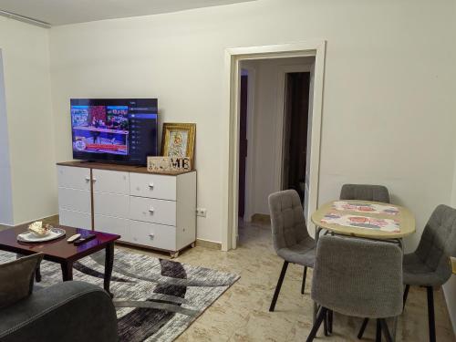 a living room with a tv and a table and chairs at LuSi in Ploieşti
