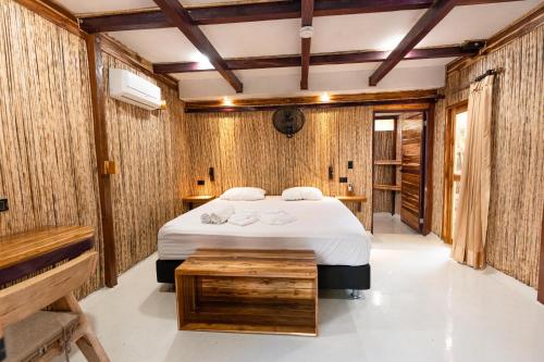 a bedroom with a bed and wooden walls at La Playita Isla Fuerte in Isla Fuerte