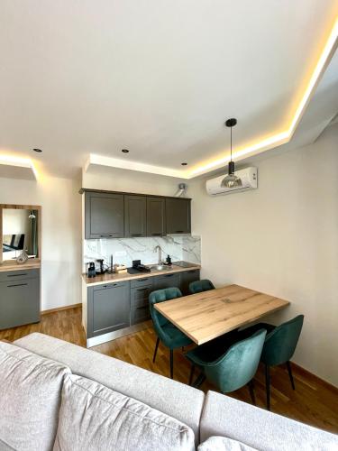 a kitchen and living room with a table and a couch at Blanc Apartments Zlatibor Center in Zlatibor