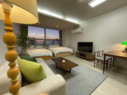 a living room with two beds and a television at 5sec from station, cosy house in Seoul