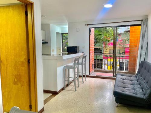 a living room with a kitchen and a bar with a couch at Hotel Torre Primavera in Medellín