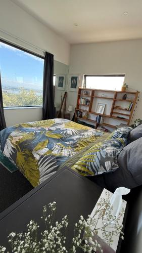 a bedroom with a bed and a large window at Luxury Retreat with Ocean Views, Sauna & Plunge in Christchurch