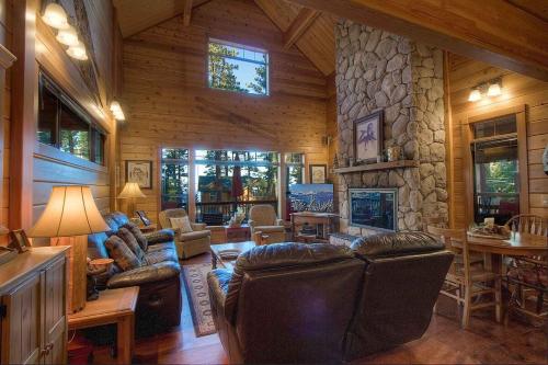 a living room with leather furniture and a stone fireplace at Smokey Joes cabin in Zephyr Cove