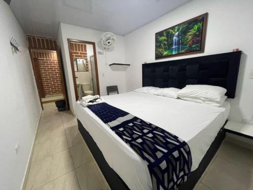 a bedroom with a large bed with a black headboard at Hotel Penthouse in Bahía Solano