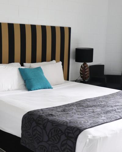 Ένα ή περισσότερα κρεβάτια σε δωμάτιο στο Colonial Palms Motor Inn