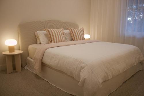 a bedroom with a large bed with two lamps on it at The Cottage in Tanunda