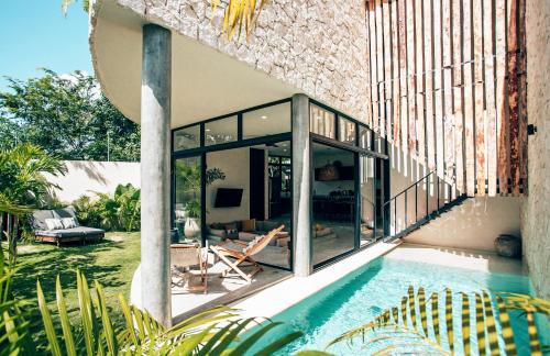 a house with a swimming pool next to a house at Boho Jungle Villa - Pvt Pool -100mbs- Concierge 7A in Tulum
