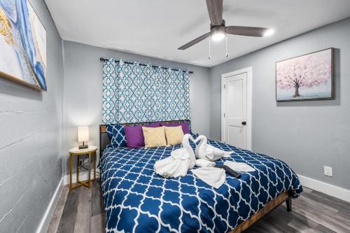 a bedroom with a blue bed with white towels on it at Chic Heights Retreat with Pool and Free Parking in Houston
