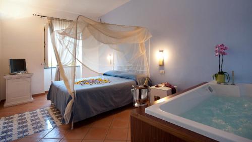 a bedroom with a bed and a bath tub at Albergo 'La Vigna' in Procida