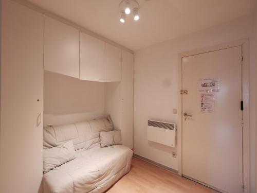 a living room with a white couch and a door at Studio by the Beach with Sea View in Oostduinkerke