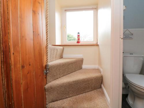 eine Treppe in einem Badezimmer mit Fenster in der Unterkunft Florence Cottage in Saltburn-by-the-Sea